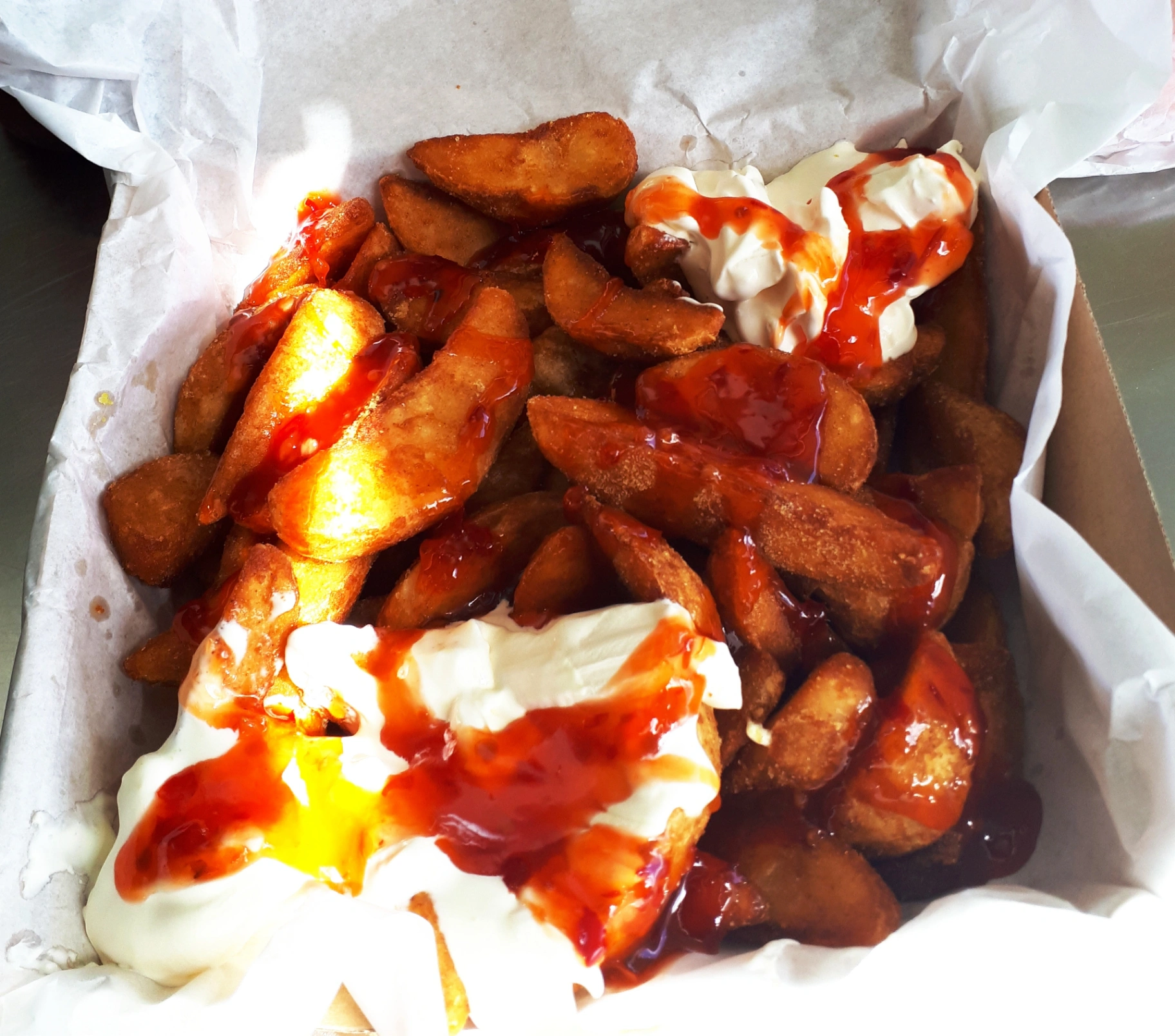 Potato wedges loaded with sour cream and sweet chilli sauce